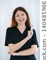 skilled aesthetician woman professional wearing black medical suit holding syringes 140485966