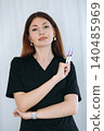 skilled aesthetician woman professional wearing black medical suit holding syringes 140485969