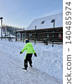 little boy in winter neon green overall skating on rink 140485974