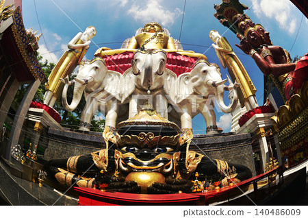 Rahu statue front of golden Buddha and tree headed elephant statue. Located at Wat Khun Jun temple in Bangkok , Thailand. 140486009