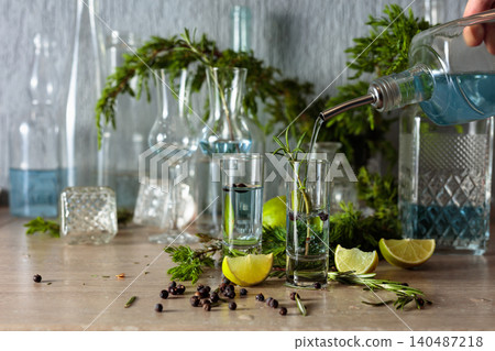 Gin is poured from a bottle into a glass. Gin is poured from a bottle into a glass. 140487218