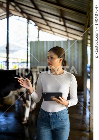Young woman with digital tablet and cows on dairy farm Young woman with digital tablet and cows on dairy farm 140487647