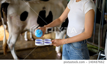 Closeup Dairy worker applying milk quality testing before milking process in farm 140487662