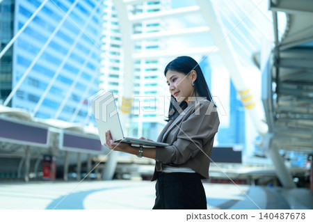 Urban businesswoman in formal attire outdoors in a financial district Urban businesswoman in formal attire outdoors in a financial district 140487678