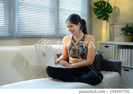 Woman using laptop after workout at home, online fitness and relaxed lifestyle concept Woman using laptop after workout at home, online fitness and relaxed lifestyle concept 140487702