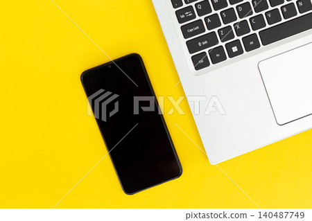 Yellow background with sleek black phone and laptop keys. Minimalist tech setup for digital creators or students. Modern design evokes focus, calm, and productivity. Perfect for blogs, ads Yellow background with sleek black phone and laptop keys. Minimalist tech setup for digital creators or students. Modern design evokes focus, calm, and productivity. Perfect for blogs, ads 140487749