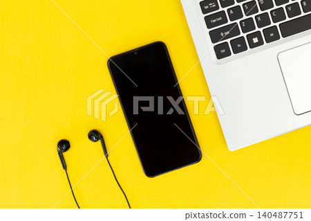 Yellow background with sleek black phone, earbuds, and laptop keys. Minimalist tech setup for digital creators or students. Modern design evokes focus, calm, and productivity. Perfect for blogs, ads Yellow background with sleek black phone, earbuds, and laptop keys. Minimalist tech setup for digital creators or students. Modern design evokes focus, calm, and productivity. Perfect for blogs, ads 140487751
