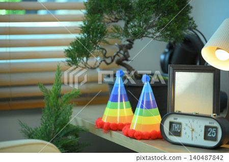 Rainbow party hats on shelf with home decor, Colorful pride themed objects in modern living space 140487842