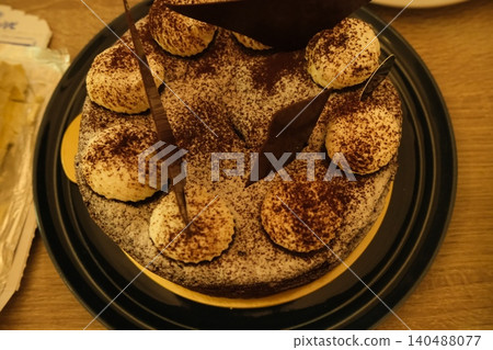 提拉米蘇蛋糕，一種盛放在黑色盤子裡的烘焙食品。 140488077