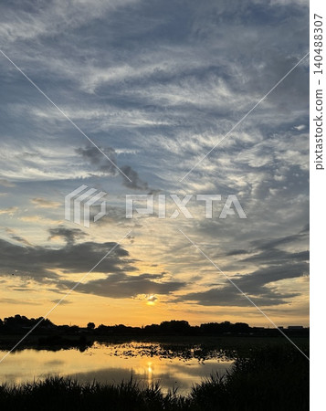 The beautiful sunrise over Jōnuma Lake, with the morning light reflecting on the water's surface. The beautiful sunrise over Jōnuma Lake, with the morning light reflecting on the water's surface. 140488307
