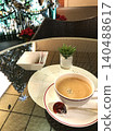 The Christmas tree lights reflected on the cafe table, along with coffee. 140488617