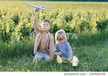 Children playing outside with toy airplanes 140488799