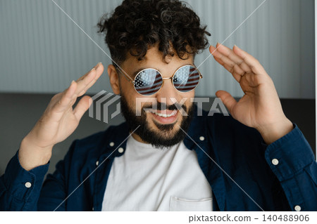 Happy man in patriotic sunglasses making a gesture Happy man in patriotic sunglasses making a gesture 140488906