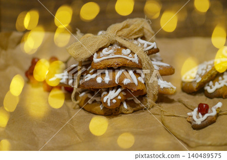 Delicious christmas gingerbread christmas tree on wooden background. Christmas colorful tree made of gingerbread cookies. Delicious christmas gingerbread christmas tree on wooden background. Christmas colorful tree made of gingerbread cookies. 140489575
