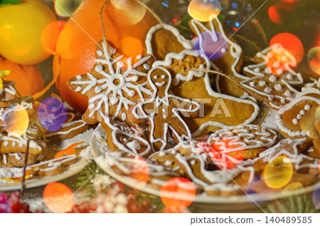 Various decorated gingerbread cookies are arranged across rustic painted wooden planks. Warm tones highlight textured details. Various decorated gingerbread cookies are arranged across rustic painted wooden planks. Warm tones highlight textured details. 140489585