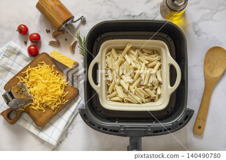 Step 4. Cooking pasta with seafood in creamy cheese sauce, in kitchen gadget modern white air fryer. Lifestyle trendy of new cooking. 140490780