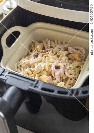 Pasta with seafood in creamy cheese sauce, in kitchen gadget modern white air fryer. Lifestyle trendy of new cooking. Copy space. Pasta with seafood in creamy cheese sauce, in kitchen gadget modern white air fryer. Lifestyle trendy of new cooking. Copy space. 140490790