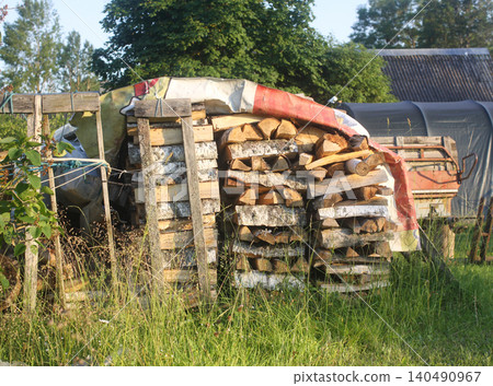 Stack of firewood in a rural yard covered with an old film texture, creating a moody vintage atmosphere. 140490967