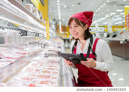 一名女員工正在超市肉品區操作平板電腦。 140491920