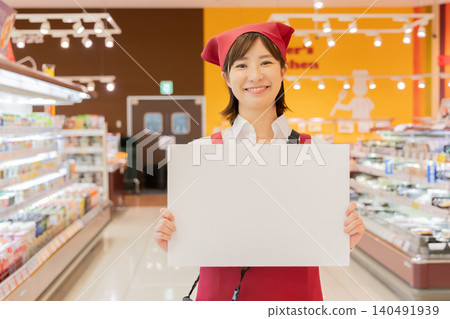 超市員工舉著指示牌引導顧客。 140491939