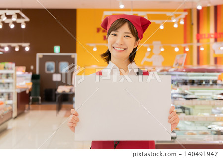 超市員工舉著指示牌引導顧客。 140491947