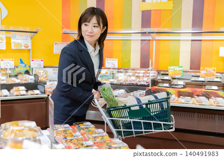 一位女商人正在超市熟食區購物。 一位女商人正在超市熟食區購物。 140491983