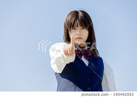 A portrait of a high school girl pointing to indicate her intentions. 140492083