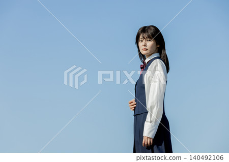 A high school girl gazes into the future against a backdrop of a blue sky. A high school girl gazes into the future against a backdrop of a blue sky. 140492106