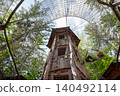 Wooden tower and mesh tunnels in forest adventure park 140492114