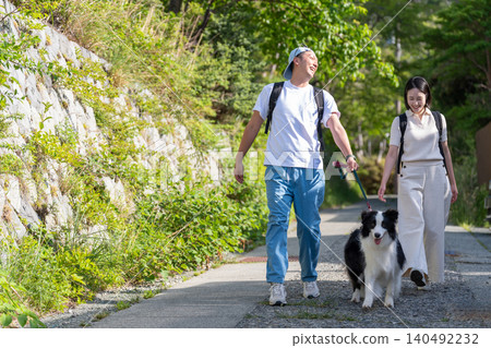 A young couple traveling with their pet, a Border Collie. A young couple traveling with their pet, a Border Collie. 140492232