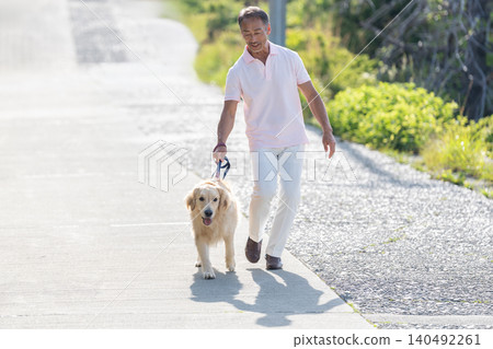 Senior man walking with a large dog Senior man walking with a large dog 140492261