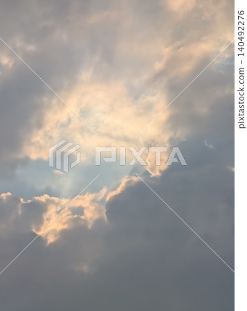 神秘的光線透過雲層的縫隙照射進來 / 夢幻般的天空景象象徵著希望和祈禱。 神秘的光線透過雲層的縫隙照射進來 / 夢幻般的天空景象象徵著希望和祈禱。 140492276