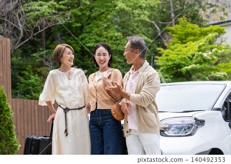 一對老年夫婦和他們的女兒一家人乘車旅行。 一對老年夫婦和他們的女兒一家人乘車旅行。 140492353