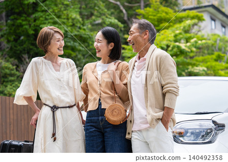 一對老年夫婦和他們的女兒一家人乘車旅行。 140492358