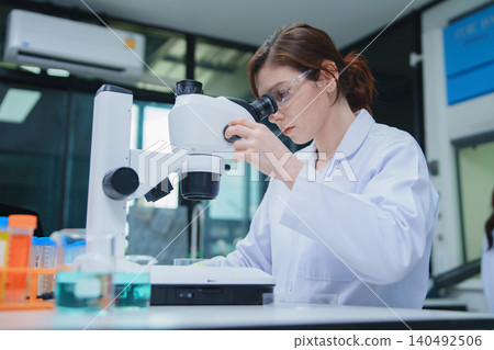 Female Scientist Conducting Research with Microscope in Laboratory 140492506
