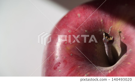 A red apple on a white table bathed in natural light. 140493020