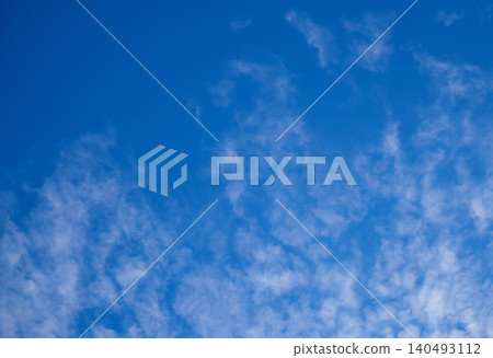 Vibrant blue sky with wispy white clouds on sunny day. Clear skyscape background with soft cirrus clouds. Vibrant blue sky with wispy white clouds on sunny day. Clear skyscape background with soft cirrus clouds. 140493112