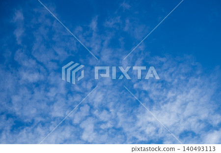 Texture of white altocumulus clouds in bright blue sky. Fluffy cloudscape pattern. Natural background in summer sunny day. Texture of white altocumulus clouds in bright blue sky. Fluffy cloudscape pattern. Natural background in summer sunny day. 140493113