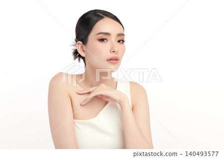 A beautiful young Asian woman with clean, fresh skin against a white background. Skincare, facial treatment, cosmetology, beauty, and spa. An elegant portrait of an Asian woman. 140493577