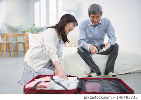 A smiling senior couple preparing for a trip. 140493736