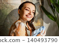 Happy young adult Caucasian woman washing hair and body in a rustic home bathroom shower 140493790