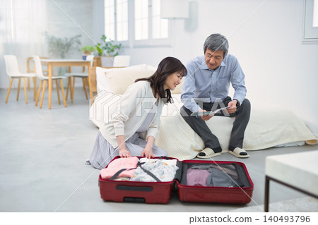 A smiling senior couple preparing for a trip. 140493796