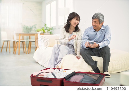 一對面帶著笑容的老夫婦正在準備旅行。 一對面帶著笑容的老夫婦正在準備旅行。 140493800