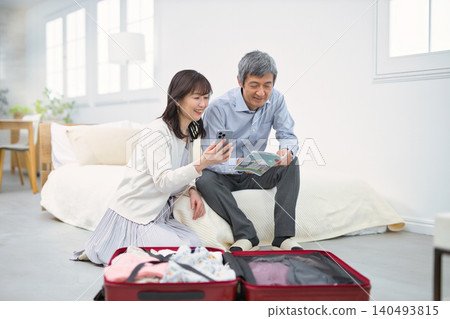A smiling senior couple preparing for a trip. A smiling senior couple preparing for a trip. 140493815
