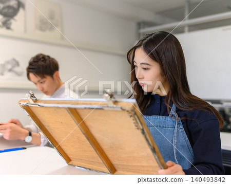 A woman seriously sketching at an art preparatory school. A woman seriously sketching at an art preparatory school. 140493842