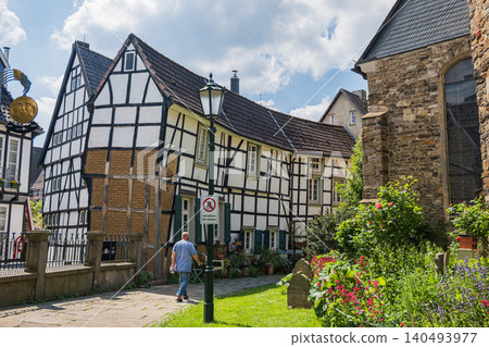 Hattingen, Germany, 26.05.2026 - Tourist man walking in Germany old town with half timbered houses, historic european architecture street view with a beautiful flower garden Hattingen, Germany, 26.05.2026 - Tourist man walking in Germany old town with half timbered houses, historic european architecture street view with a beautiful flower garden 140493977