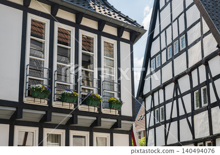Germany half timbered house windows with flower boxes, historic old town european architecture closeup, traditional medieval village wooden frame facade in summer Germany half timbered house windows with flower boxes, historic old town european architecture closeup, traditional medieval village wooden frame facade in summer 140494076