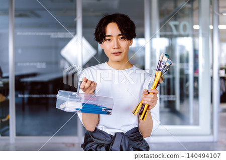 藝術預科學校的男生，手持美術用品。 140494107