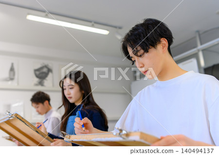 一名男子在藝術預科學校專心致志地畫畫。 140494137