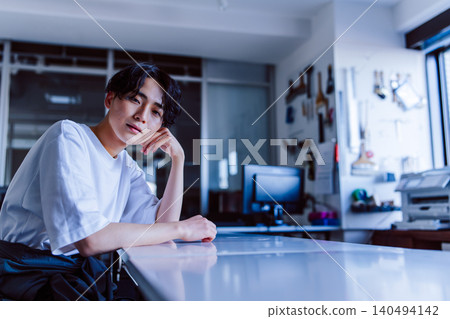 一名男子坐在藝術預科學校的桌子前。 140494142